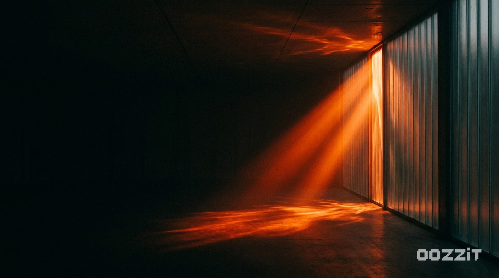 Molten orange light refracting through tall fluted glass ribs in a dark room